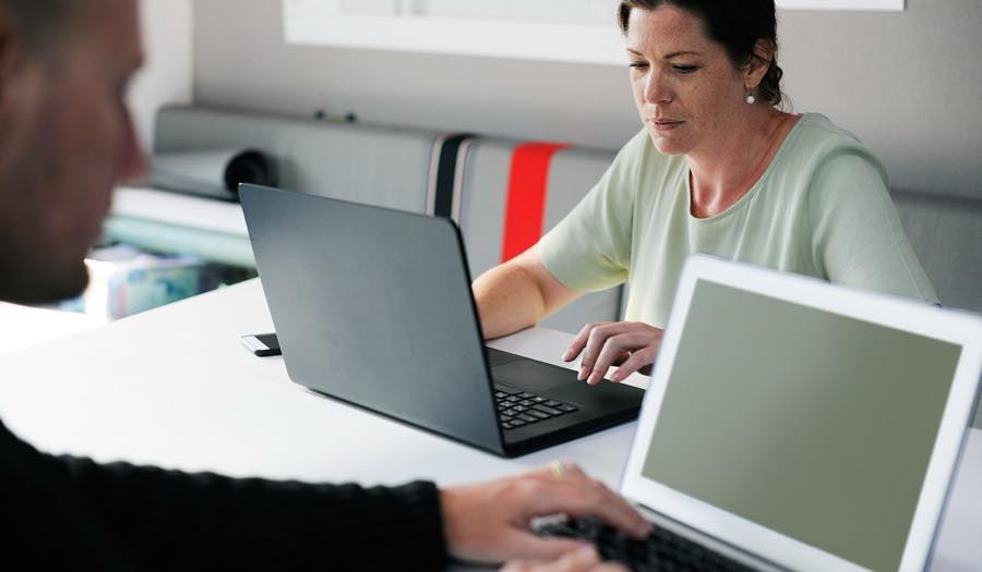 Deux collaborateurs d'une petite entreprise travaillant sur un ordinateur portable
